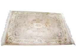 A large Chinese style pale pink wool rug.