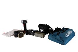 An assortment of cameras, binoculars and tools.