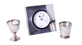 Two silver cups and a silver framed clock.