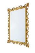 A large contemporary baroque style gilt framed wall mirror.