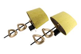 A pair of contemporary brass wall light sconces. Having asymmetric cast brass decoration.