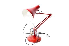 A modern adjustable Anglepoise desk light. Red with a circular weighted base. Max H74cm.