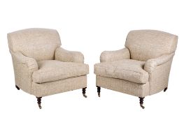 A pair of contemporary armchairs in the style of Howard & Sons.
