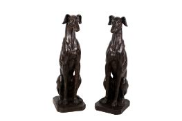 A pair of plaster cast life sized greyhound dog figures.