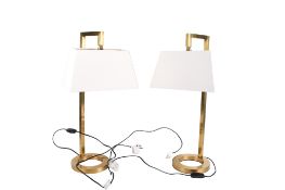A pair of contemporary brass table lamps. Raised on an open circular base.