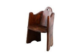 A small Arts and Crafts style wooden armchair.