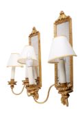 A pair of contemporary antique style two-light wall sconces. With mirror backs and gilt finish.
