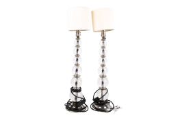 A pair of contemporary stacked glass ball table lamps. Raised on a polished nickel circular bases.