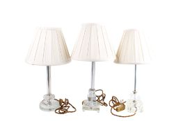 A group of three assorted contemporary glass table lamps.
