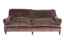 A large sofa and footstool, the sofa in the style of Howard & Sons.