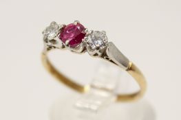 An 18ct gold and platinum (stamped) three stone ring. Set with one round faceted pink sapphire of 0.