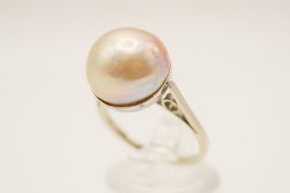 A 9ct gold cultured pearl ring. The pearl circa 12mm diameter, in a dish mount, marked 9ct.