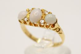 An 18ct gold Edwardian dress ring. Set with three cabochon cut opals of 0.