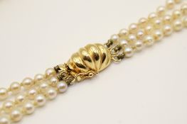 A graduated three strand freshwater pearl necklace.