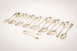 A group of silver teaspoons and sugar tongs.