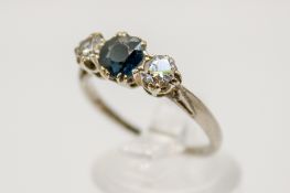 An 18ct white gold, sapphire and diamond ring. The central stone circa 0.