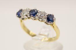 An 18ct sapphire and diamond five stone ring. The two round cut diamonds circa 0.