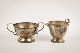 A George V silver cream jug and twin handled sugar bowl.