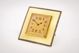 An early 20th century silver and yellow enamel trapeze clock.