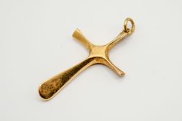 A 15ct gold propeller form cross pendant.