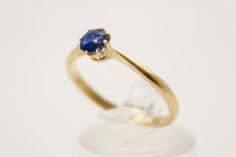 A yellow metal and blue stone ring. The blue faceted stone circa 4.