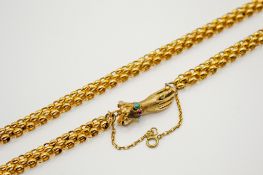 A yellow metal necklace with hand form clasp.