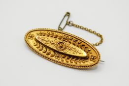 A Victorian yellow metal Etruscan style brooch.