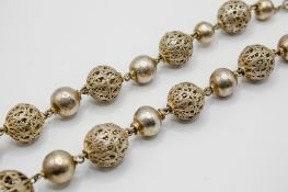 A silver pierced bead necklace.