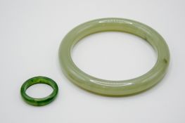 A pale green jade bangle and a ring.