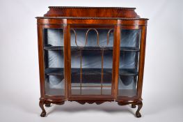 An Edwardian mahogany glazed serpentine display cabinet.
