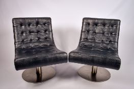 A pair of black New Yorker lounge chairs. Raised on a pedestal with heavy circular metal base.