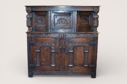 A Jacobean style carved oak court cupboard.