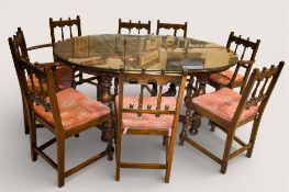 A Mid-century Ercol stained elm extending dining table and eight chairs.