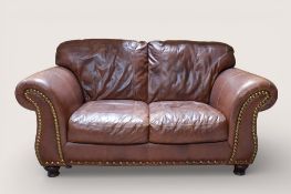 A contemporary brown leather two seater sofa.