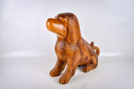 A vintage carved wooden model of a dog. In a seated position, unsigned, H44cm.