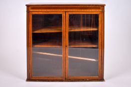 An Edwardian inlaid mahogany glazed bookcase.