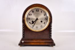 A 1920s oak cased mantel clock.