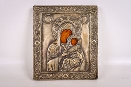 A white metal mounted Russian icon of Madonna and child.