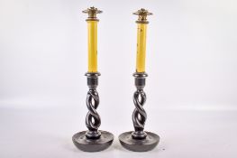 A pair of oil lamps modelled as candlesticks. With ebonized twist bases.