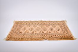 A Persian style wool rug on a light brown ground.