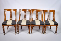 A set of four Victorian carved walnut dining chairs with black and white seats.