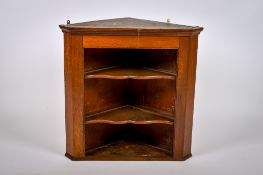 A Georgian oak hanging corner wall cabinet with shaped shelves. Having two fixed shelves.