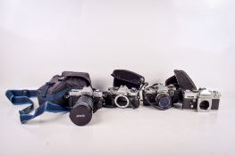 A group of four vintage SLR film cameras.