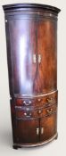 An early 20th century mahogany bow fronted corner cabinet.