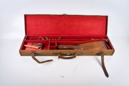 A vintage canvas covered shot gun case with leather straps and some accessories.