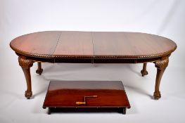 A 20th century Chippendale Revival style wind-out extending mahogany D-end dining table.