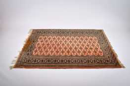 A Persian style wool rug on a cinnamon ground.