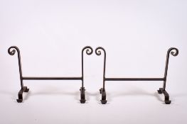 A pair of iron fire dogs. Having scrolling feet, H38cm x W56cm.