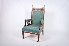 An Edwardian carved mahogany open arm library chair.