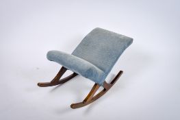 A light blue upholstered rocking 'gout' stool. Having a wooden base.